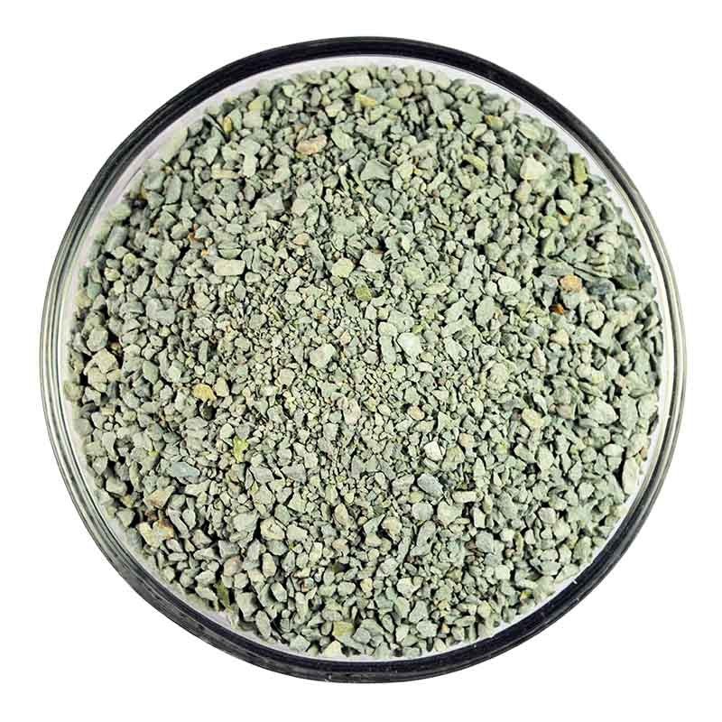 Close-up of pale green granular zeolite for improving soil structure and nutrient absorption.