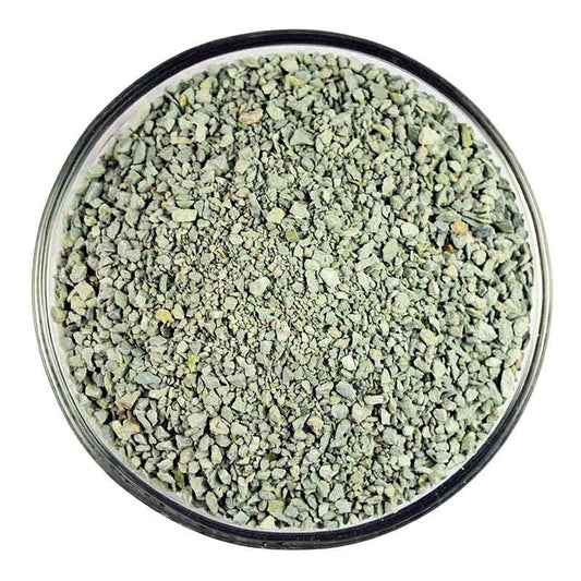 Close-up of pale green granular zeolite for improving soil structure and nutrient absorption.